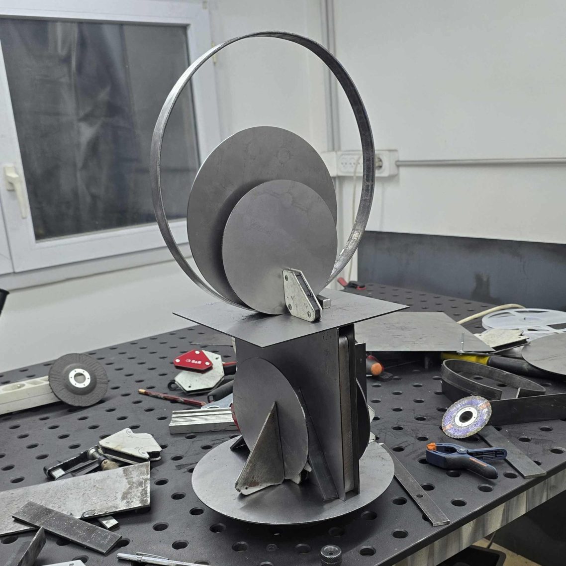 Carnet de création – L’origine d’une lampe Sype, travail artisanal sur acier brut. Sculpture lumineuse en acier brut en cours d’assemblage dans l’atelier Sype Design – genèse d’une lampe contemporaine.