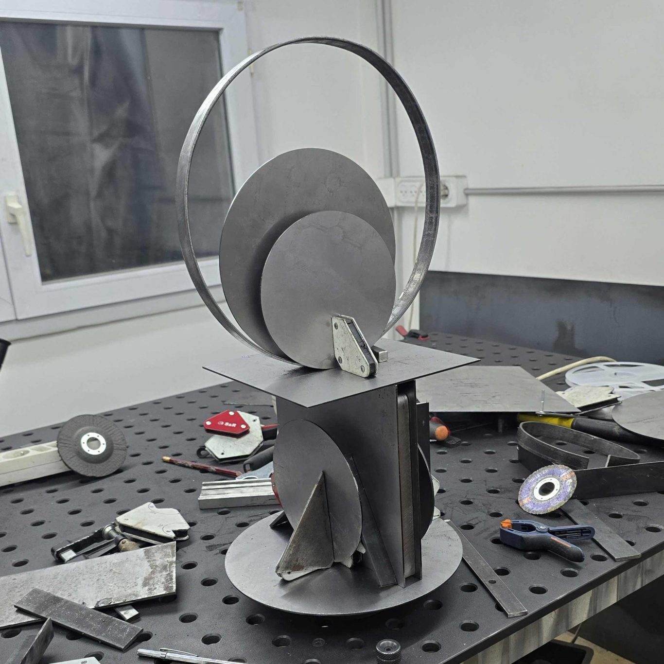 Carnet de création – L’origine d’une lampe Sype, travail artisanal sur acier brut. Sculpture lumineuse en acier brut en cours d’assemblage dans l’atelier Sype Design – genèse d’une lampe contemporaine.