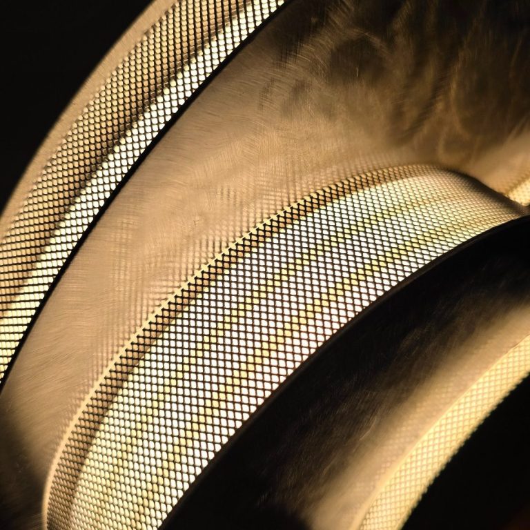 Empilement de formes circulaires en acier dans Éclipse Sonore, créant profondeur visuelle et rythme lumineux.