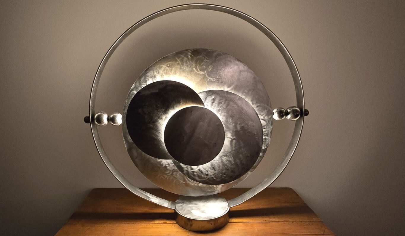 Éclipse Sonore Sype 015, sculpture lumineuse en acier brut où disques et cercles se superposent dans une harmonie métallique.