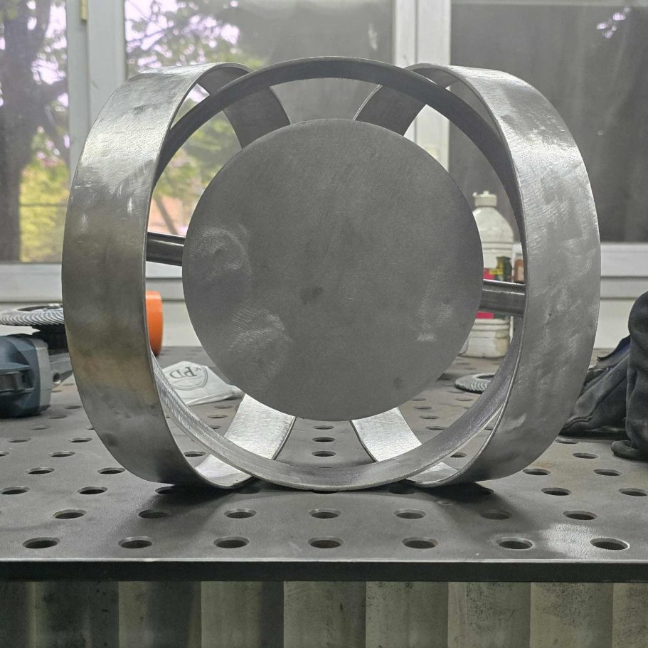 Sype 021 – Simplified Circular Steel Structure Experimental contemporary steel sculpture featuring simplified circular rings around a central metal disc in the Sype Design workshop.
