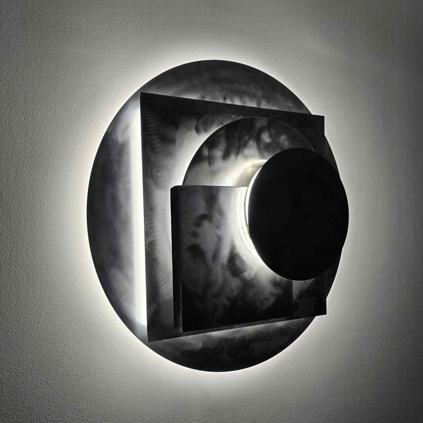 Sype 011 Planètes en orbite, applique murale circulaire en acier brut jouant sur les reliefs et les ombres..