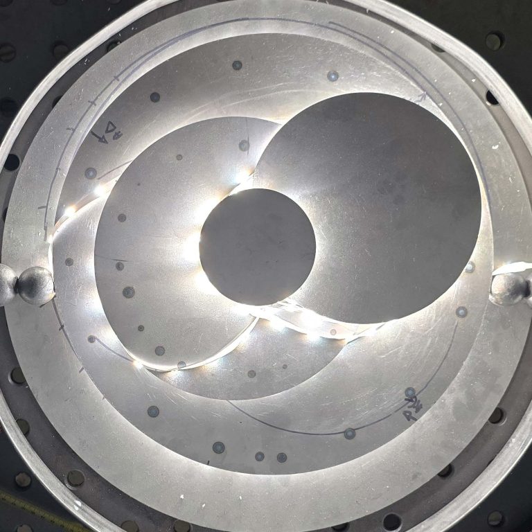 Regards sur la lumière – L’acier devient matière de lumière. Œuvre lumineuse circulaire en acier brossé avec halo central – création signée Sype Design.