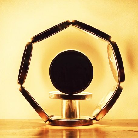 Lampe design en acier brut, base pivotante et cercles concentriques effet solaire, sculpture lumineuse contemporaine