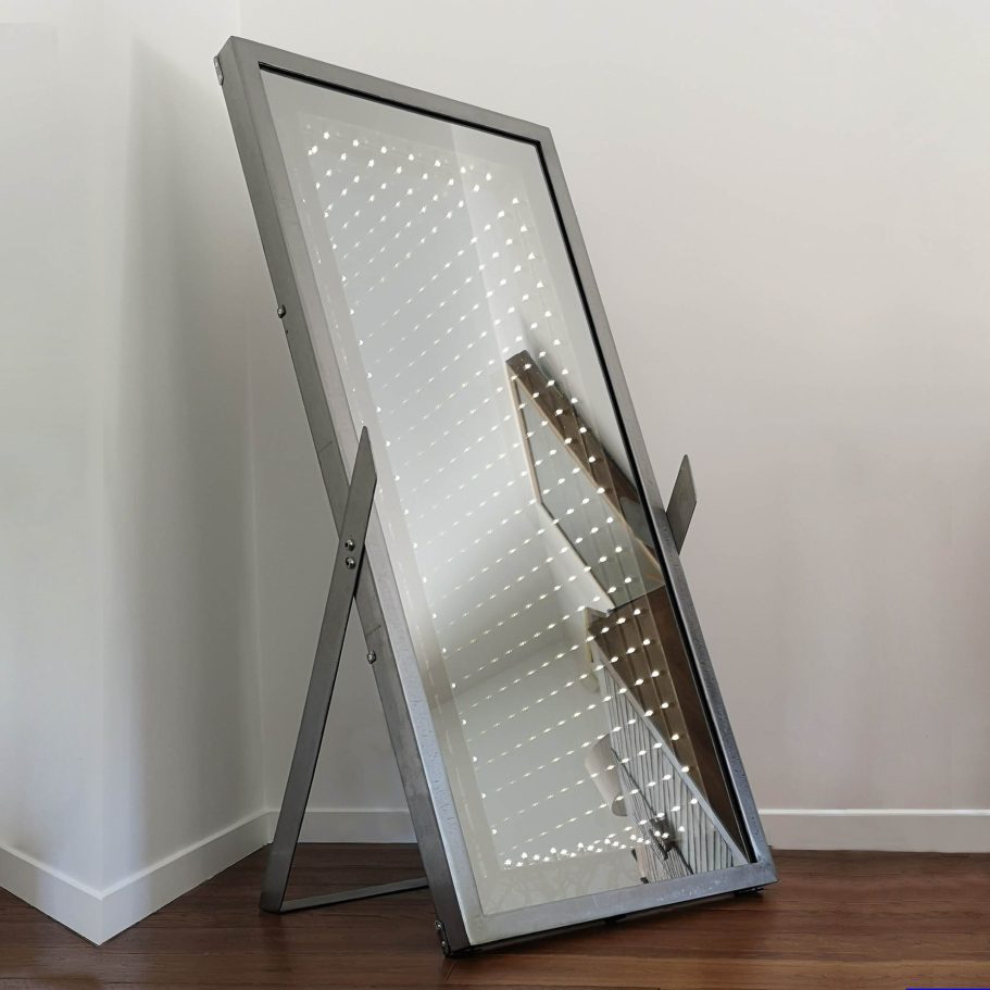 Miroir infini sur pied Sype 002, œuvre en acier brut dans un intérieur contemporain.