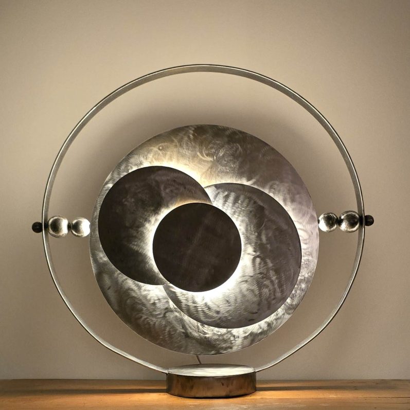 Éclipse Sonore, sculpture lumineuse en acier de Sype Design, œuvre signature composée de disques circulaires et lumière intégrée.
