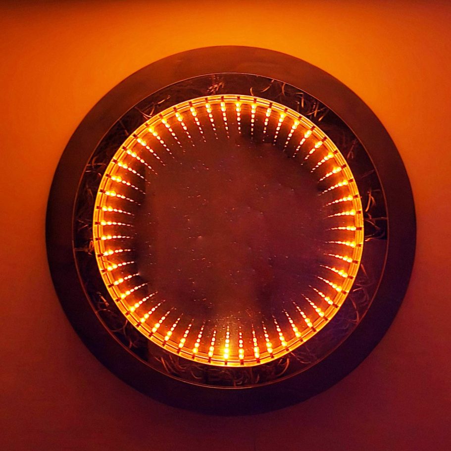 Sype 013 Miroir infini rond, illumination LED chaude révélant la structure en acier et la spirale de lumière interne.