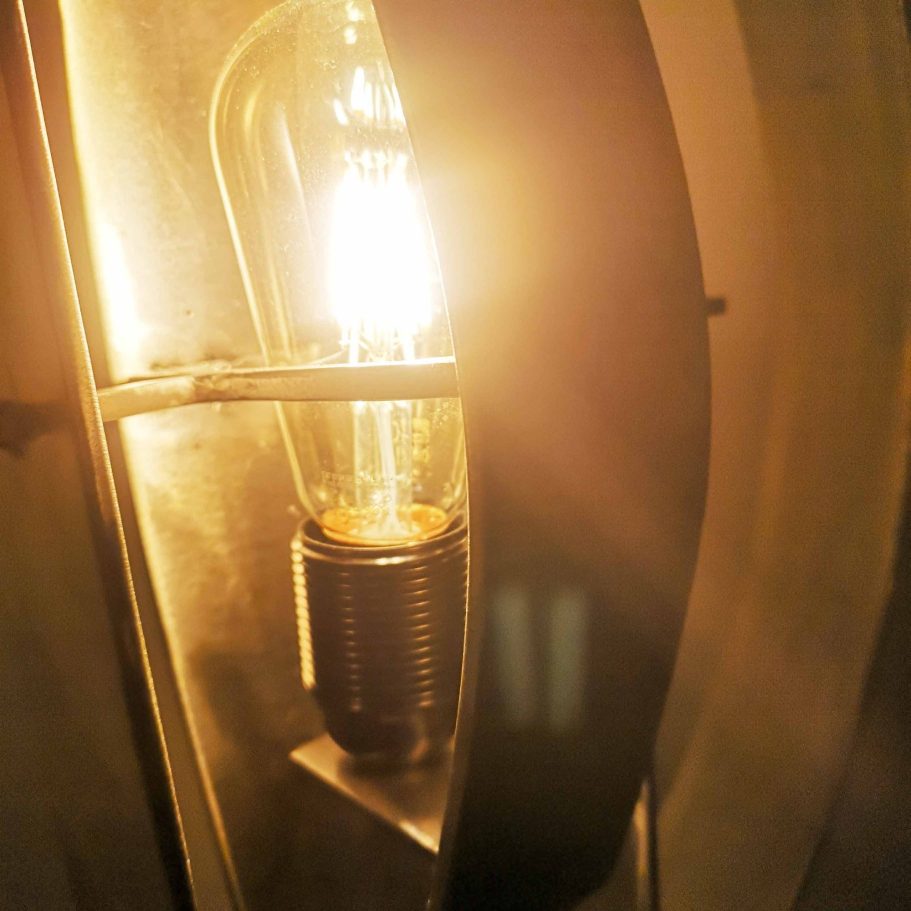 Détail lumineux de la lampe Sype 009 Le Compas, jeu d’ombres et reflets sur acier brut poli.