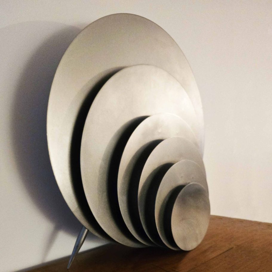 Détail latéral de la lampe  Sype 012 éteinte. Danse des Cercles, profondeur sculpturale et jeux d’ombres en acier brut.