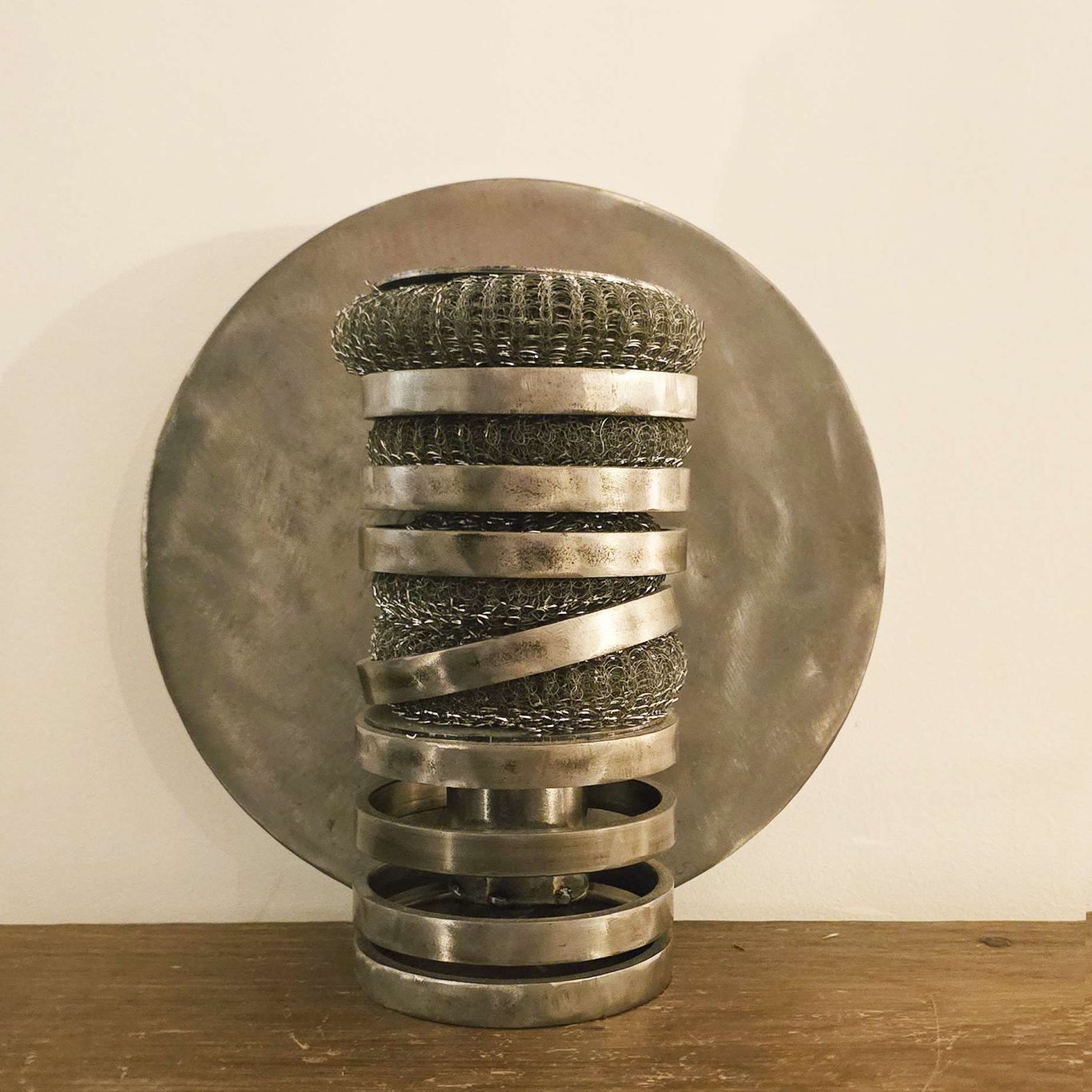 Lampe Spirale d’acier Sype 006, disque d’acier poli révélant une lumière circulaire contemporaine.