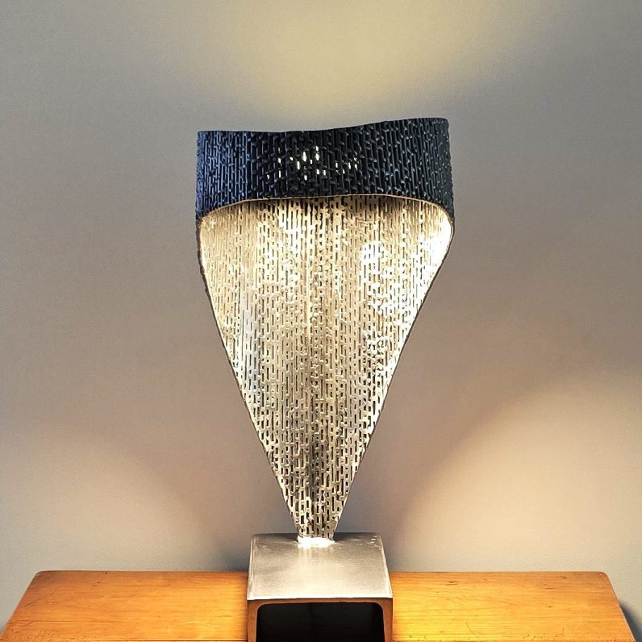 Sype 017 – Détail texture et lumière Détail du luminaire Sype 017, entrelaçage d’acier et texture brute pour un effet de lumière sculpté.