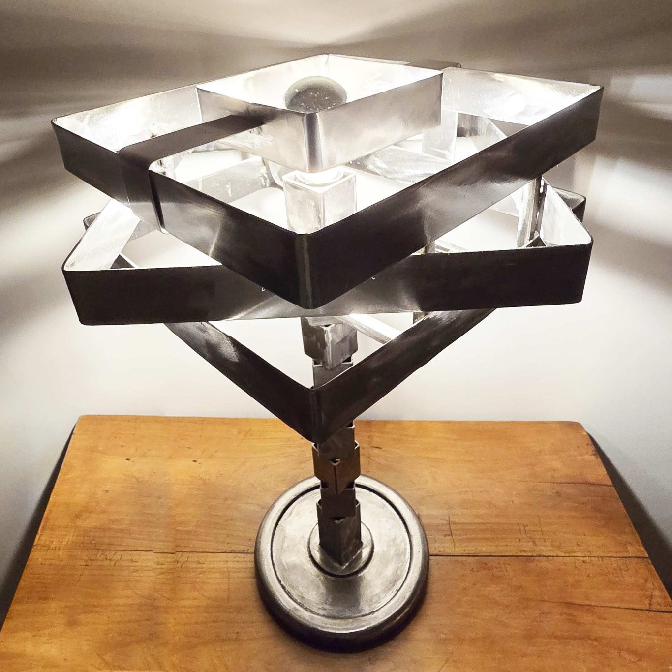 Sculpture lumineuse Sype 003, empilement de carrés d’acier autour d’une ampoule mirroir.