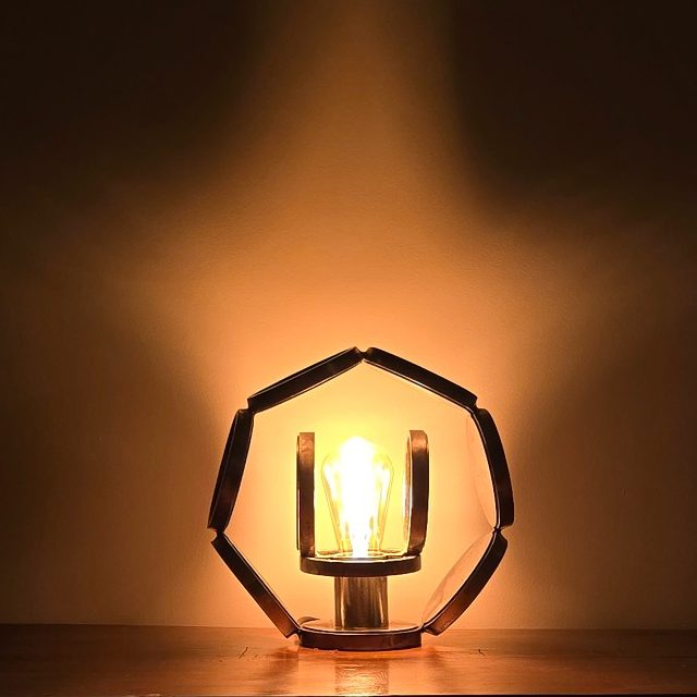Sype 005 – Halo lumineux en étoile Étoile d’acier Sype 005, sculpture lumineuse en acier brut projetant un halo lumineux en forme d’étoile.