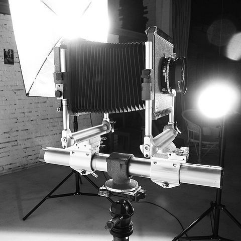 Inspiration & Influences – Héritage photographique et maîtrise de la lumière Chambre photographique argentique sur trépied dans un studio éclairé – hommage aux origines artistiques de Sype Design.